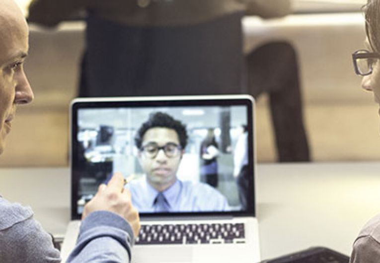 two people having a video conference call on a laptop