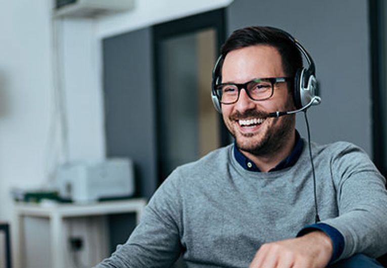 man with headset mic working at computer
