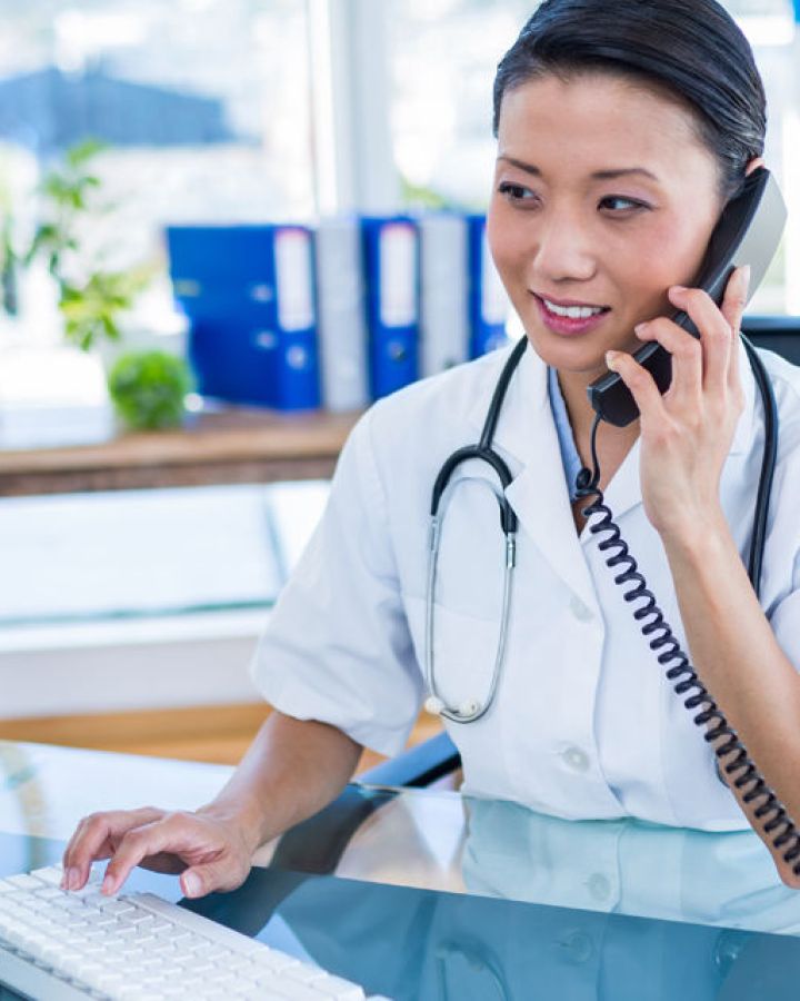 woman at desk talking on phone