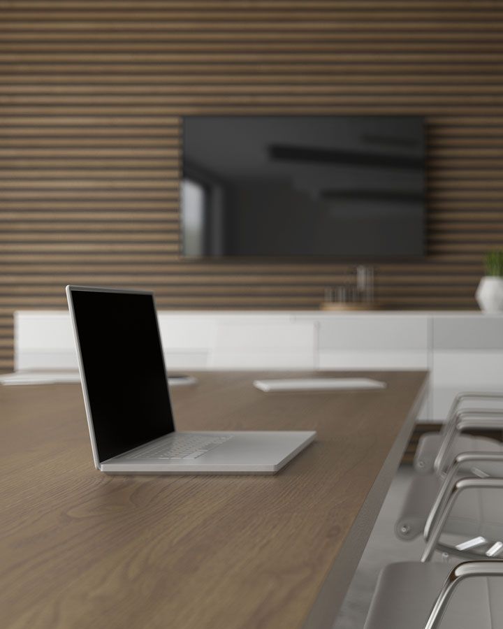 labtop on table with tv on the wall behind it