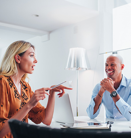 woman and a man having a discussion at a desk