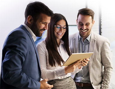 two men and a woman looking at a tablet