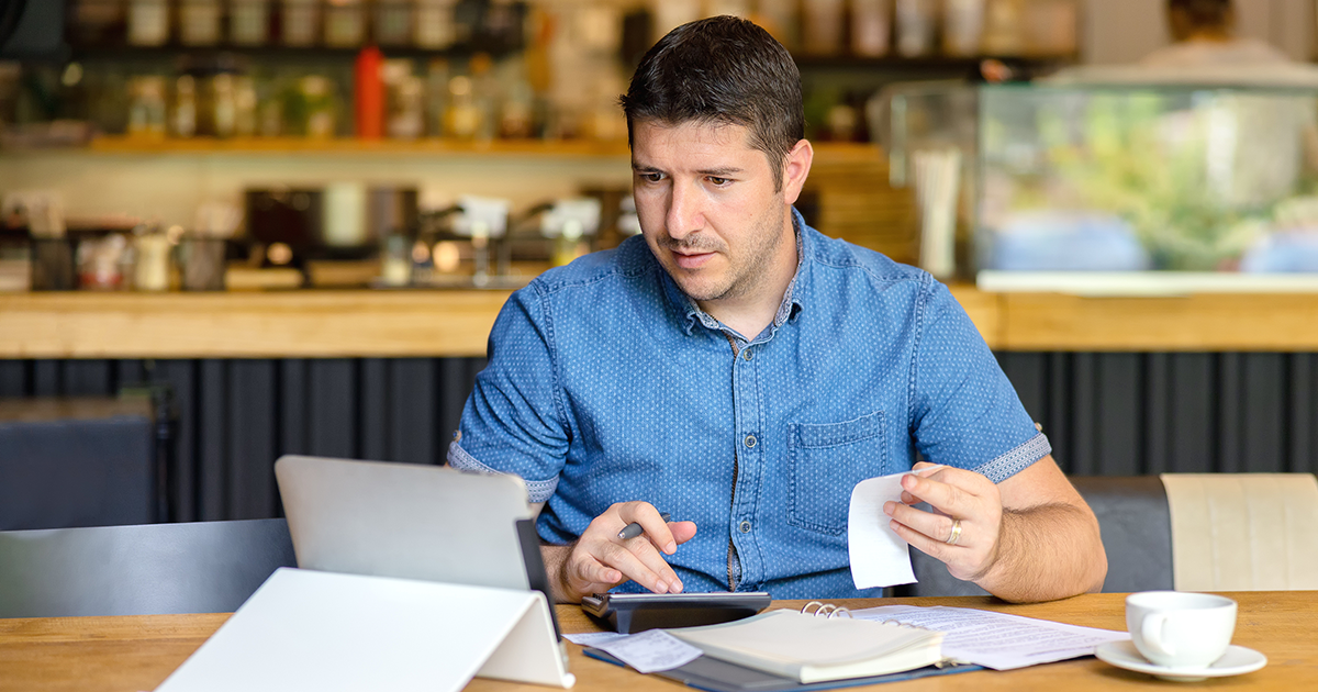 Mature small business owner calculating finance bills of activity