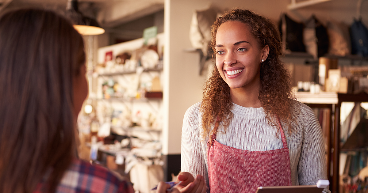 Sales Assistant With Credit Card Reader On Digital Tablet