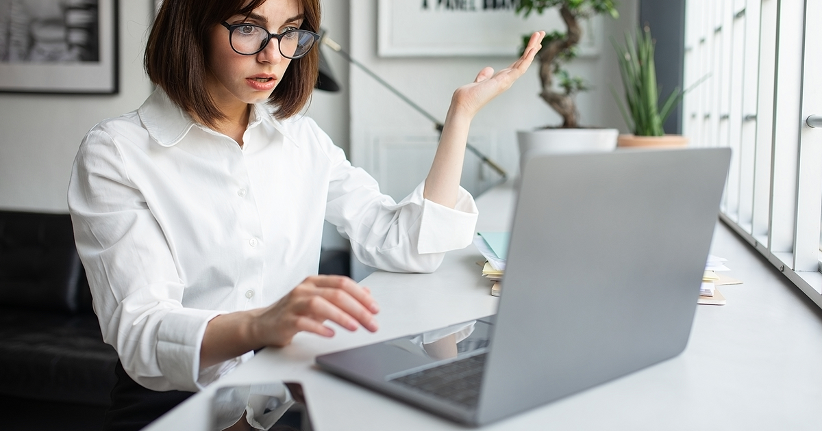 Shocked businesswoman looking at laptop with disbelief, working in coworking space, office.