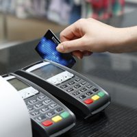 An image of a person swiping their credit card through a POS system