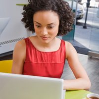 A woman sitting at a desk on her laptop.