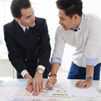 Two men working on business plans at a table.